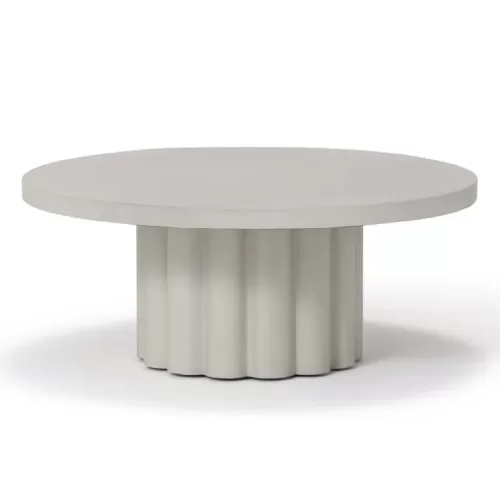 A white circular coffee table with a scalloped column base.