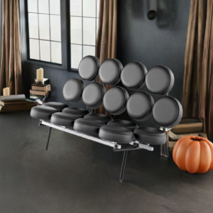 George Nelson Marshmallow Sofa in black shown in dark interior with a pumpkin.